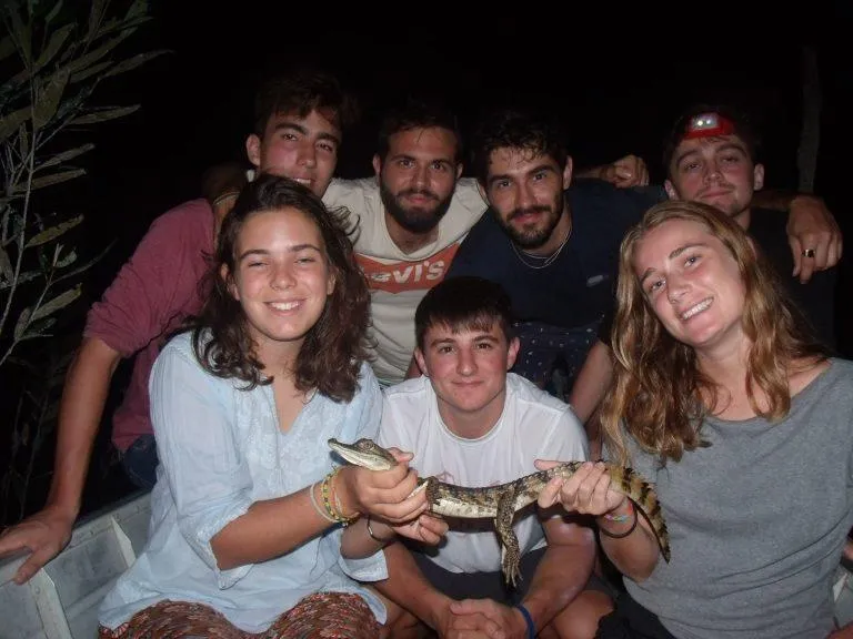 A small group observing a caiman with their guide after dark